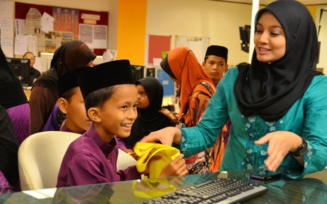 Penyampai berita Marlina Manaf menunjukkan cara menyampaikan berita kepada seorang anak yatim.