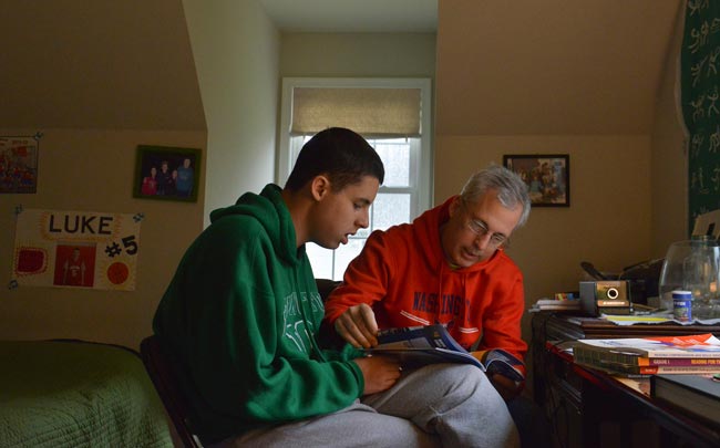 SHUTDOWN PAY: Luke Ferris, 17, left, does reading comprehension lessons with his father John Ferris on Oct. 10, 2013 in Falls Church, Va. With both of Luke Ferris' parents furloughed because of the federal shutdown, they recently opted to do without the reading specialist who had been working with Luke, who has autism.(Washington Post photo by Jahi Chikwendiu) 
