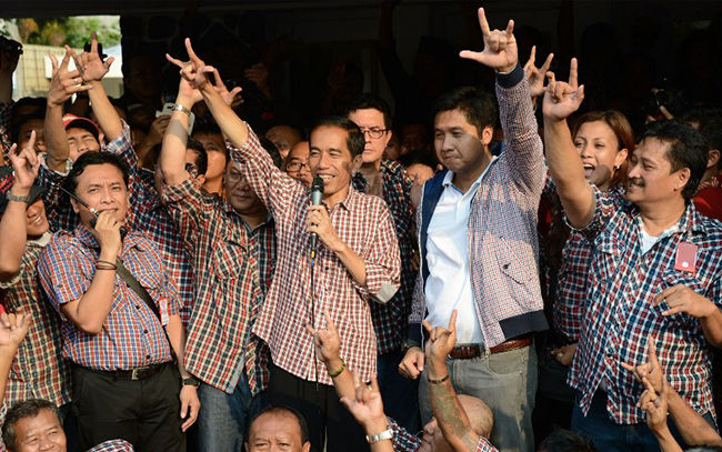 Governor elect Joko Widodo (C with microphone) gestures as he delivers his speech in a press conference in Jakarta on September 20, 2012. (AFP PHOTO / ADEK BERRY)