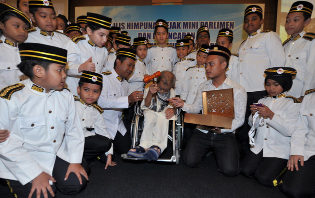 Allahyarham  Pak Cik Jamal (tengah) menyerahkan 'Cokmar Mini Parlimen' kepada speaker baharu Mini Parlimen pada 23 Februari. -- fotoBERNAMA