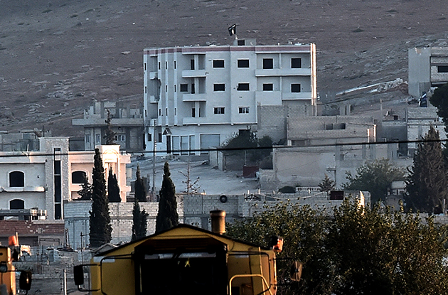 Another Islamic State flag flutters on the roof of a building inside Kobane (AFP Photo / Aris Messinis)