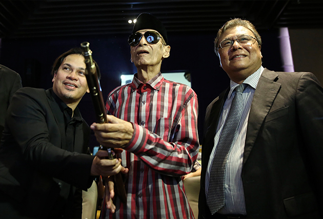 Norman Abd Halim (left) helping Tan Sri Jins Shamsudin during the launch of the Bukit Kepong HD film trailer 