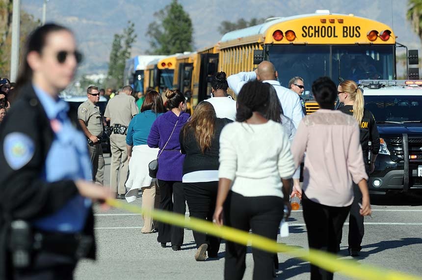 Deputies and officers from several law enforcement agencies escort people from the building and surrounding buildings at the site of a mass shooting that killed multiple people and wounded others.