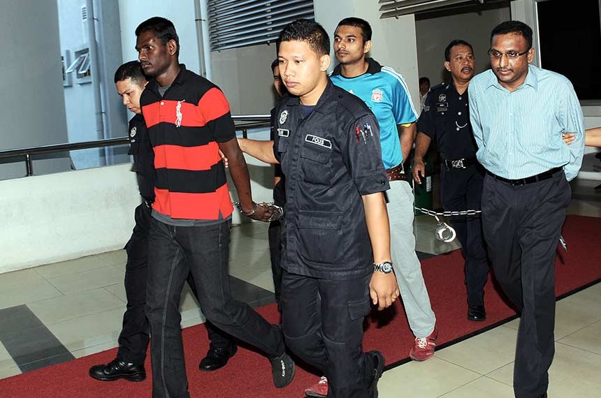 The three men R. Matan (second, left), T Thilaiyalagan (fourth, left) and former lawyer N Pathmanabhan (right) was escorted by police following the courts judgement. 