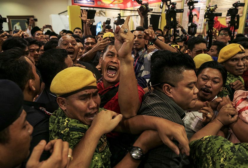 Kejadian tolak-menolak dan rempuhan antara satu sama lain berlaku semasa Muhyiddin beredar dari Dewan Tun Dr Ismail. - Foto Astro AWANI / SHAHIR OMAR