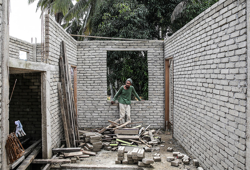 As he speaks, his gaze keeps falling back on the Lebir River which runs behind the house. Two of his daughters drowned in its milk-tea waters back in 2011. And each year, the same river threatens to swallow up the village. The sky is a clear blue, with beautiful white clouds. But there is a promise of grey. Looking through the windowless frame of the half-completed attic, we can see drift wood carried by the Lebir's strong current. It's waters are rising. It must be raining heavily somewhere upriver. What's bound to happen next is all to familiar to Azami and folks from these parts. And the thought of moving has crossed his mind. But his heart won't allow him to entertain such thoughts for too long.