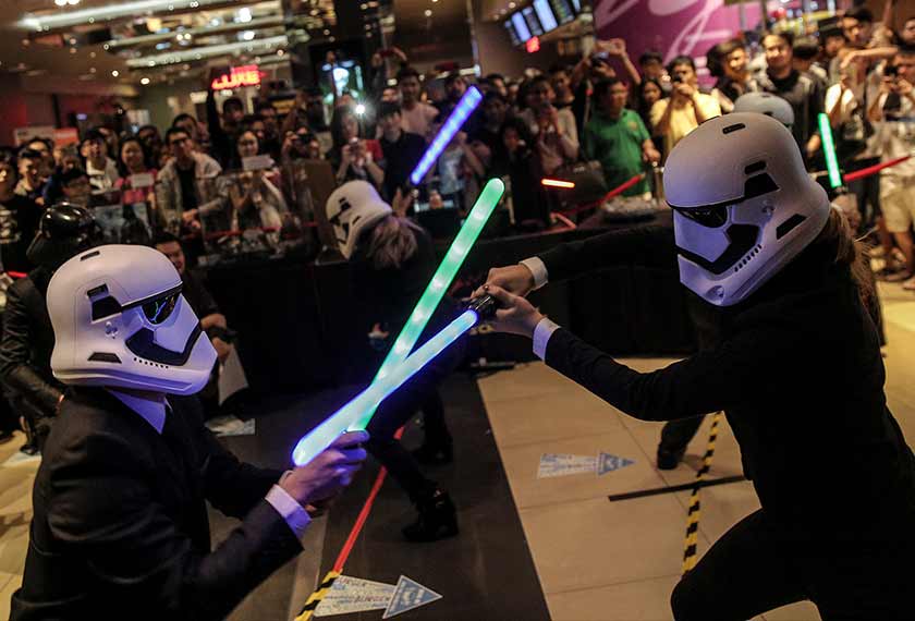 Star Wars fans donning Stormtrooper helmets seen here battling each other with lightsabers before the midnight premiere of Star Wars: The Force Awakens at the TGV cinemas in Sunway Pyramid on Dec 17, 2015. - Astro AWANI/Shahir Omar