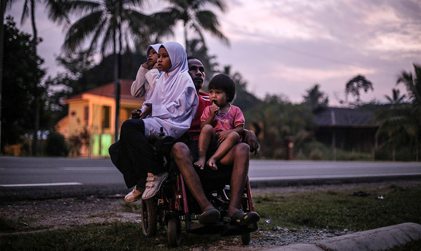 Dedikasi seorang ayah terserlah apabila setiap hari Rosli menghantar dan menjemput pulang kedua-dua anaknya itu meskipun hanya berkerusi roda. - Foto Astro AWANI/SHAHIR OMAR