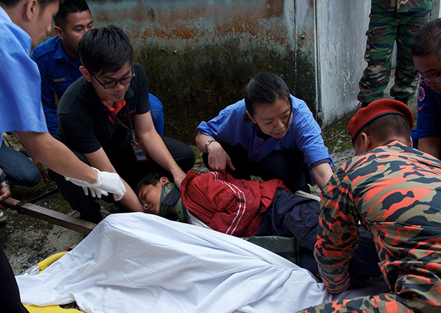 An injured child being attended to by search and rescue personnel before being brought to the Ranau Hospital. - BERNAMA Photo 