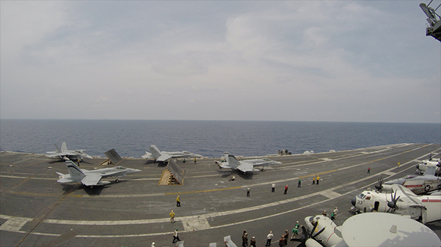 A cluster of fighter jets waiting to take-off on the USS Carl Vinson.