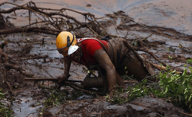 A rescue worker searches for victims at Bento Rodrigues