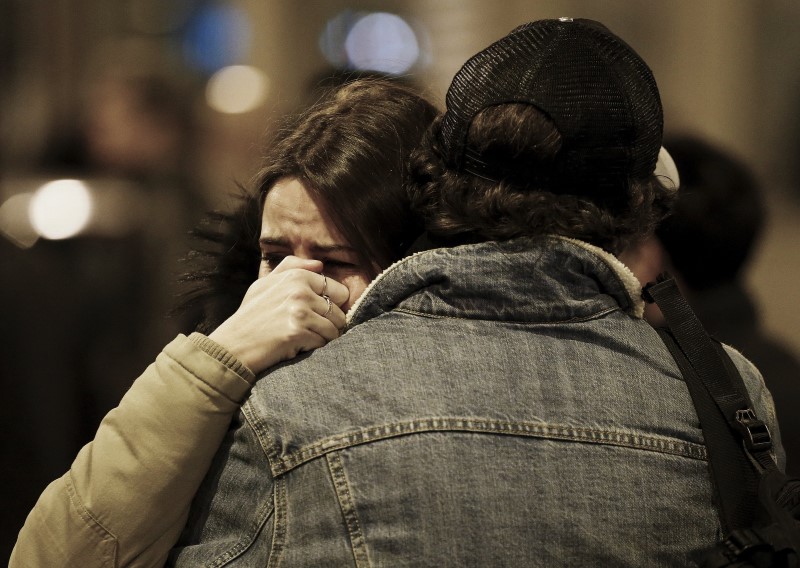 People react near the scene of a shooting the day after a series of deadly attacks in Paris