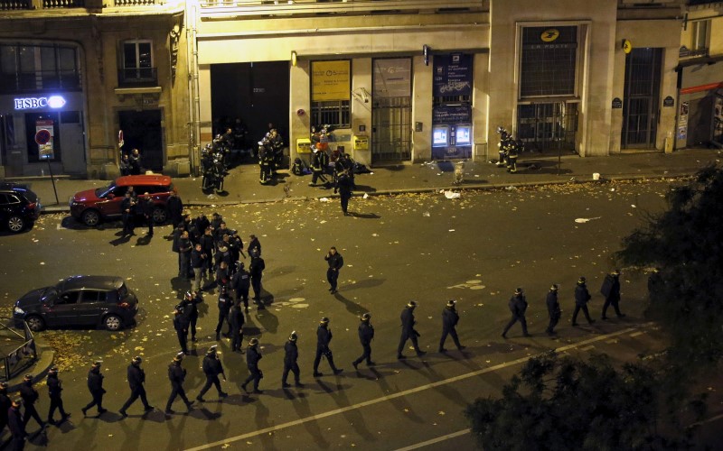 French police with protective shields walk in line near the Bataclan concert hall. -REUTERS
