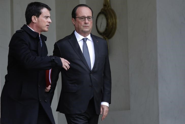 French President Francois Hollande speaks with Prime Minister Manuel Valls (L)