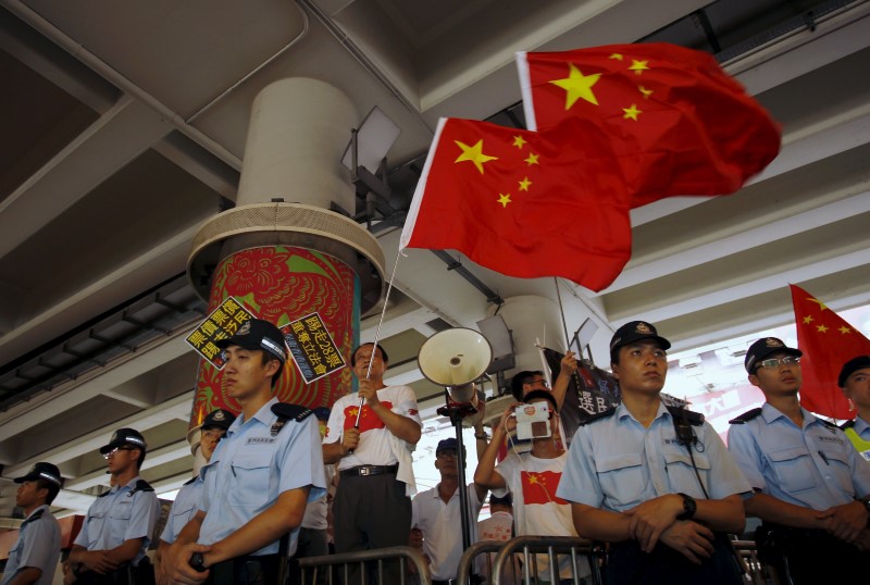 Pro-China supporters wave Chinese national flags in Hong Kong, China July 1, 2015, the day marking the 18th anniversary of Hong Kong's handover from Britain to Chinese sovereignty. REUTERS/Liau Chung-ren