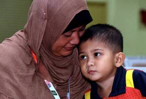 Isteri Allahyarham Shahidan Saad, Maziatunazna Bidin @Ibrahim, 44, (kiri) bersama anak tunggalnya Muhammad Afiq Amzar, 3.