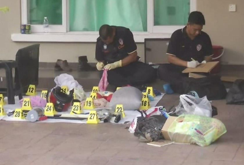 Polis forensik sedang meneliti barang-barang di tempat kejadian di mana jenayah tersebut berlaku.