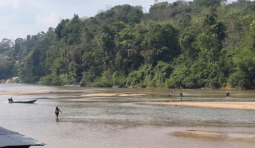 Disebabkan air sungai yang cetek, mereka hanya sekadar perlu berjalan kaki menyeberangi sungai. - Foto Astro AWANI