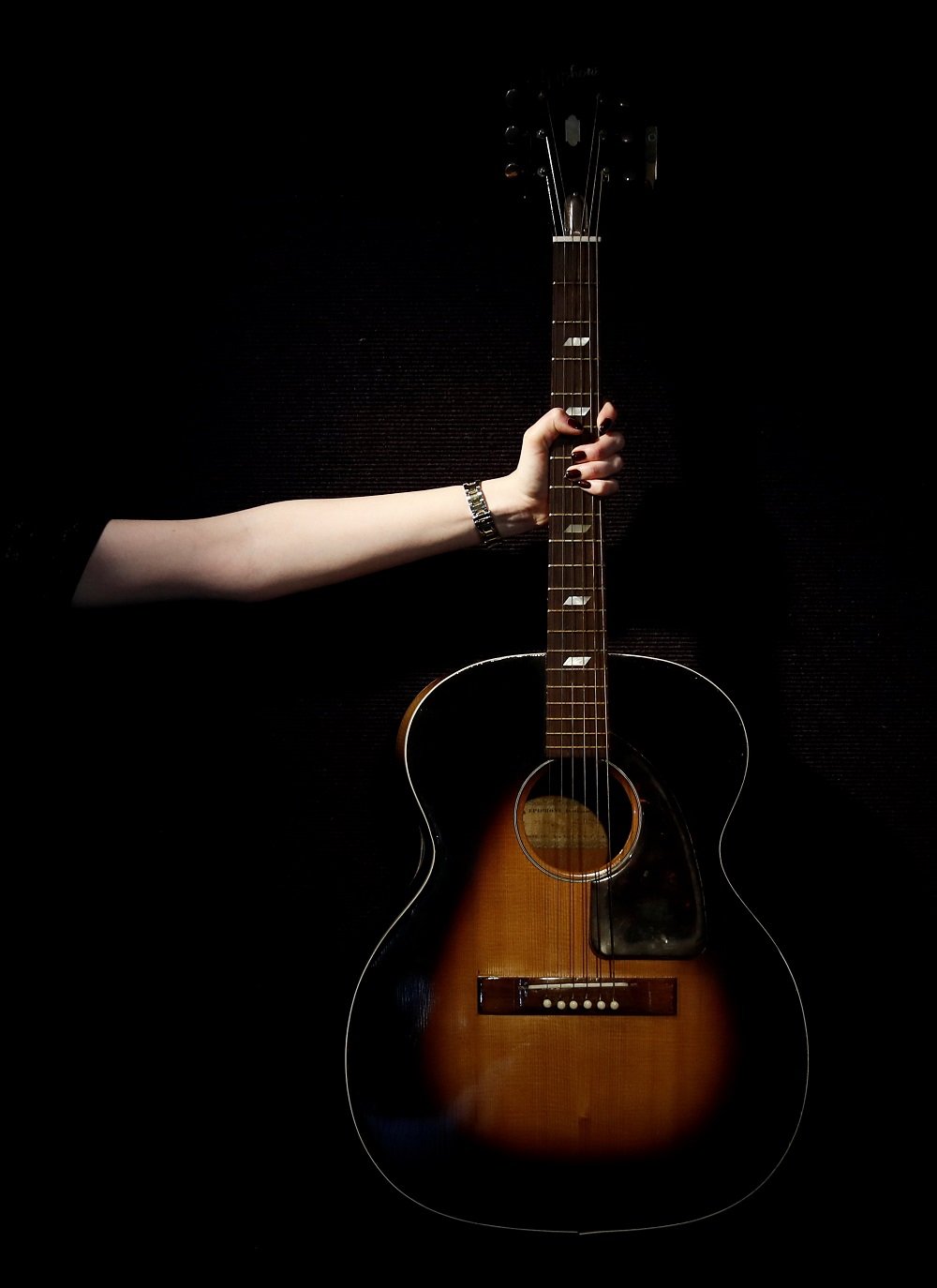 A Bonhams assistant displays an Epiphone FT79 Acoustic Guitar owned and played by Jimi Hendrix in central London, Britain December 12, 2016. REUTERS/Stefan Wermuth