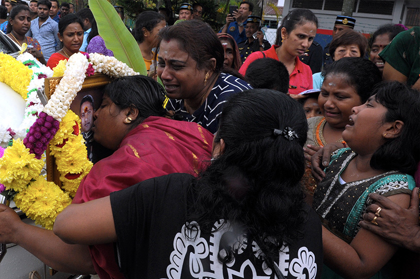 S. Usha mencium potret suaminya mendiang Mejar C. Kayamboo semasa jenazah juruterbang Tentera Udara Diraja Malaysia (TUDM) itu dibawa ke tanah perkuburan Hindu Batu Lanchang untuk upacara pengebumian hari ini. - Foto Bernama
