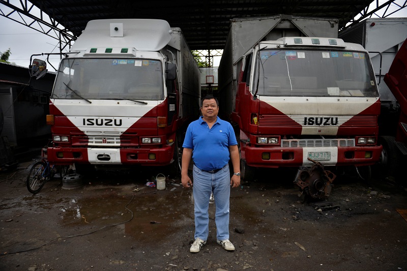 Jose Cecilia Jr., 51, poses for a photograph in front of trucks at a trucking company he owns in Santa Rosa, Laguna, south of Manila, Philippines December 2, 2016. 