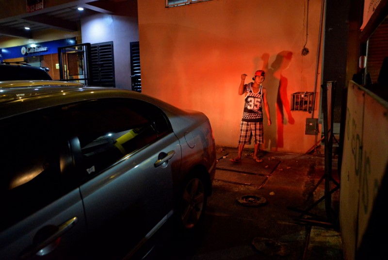 Graciano De Leon, 19, parking attendant, instructs a motorist who is parking a vehicle outside a grocery shop in Paranaque city, Metro Manila, Philippines October 14, 2016. 