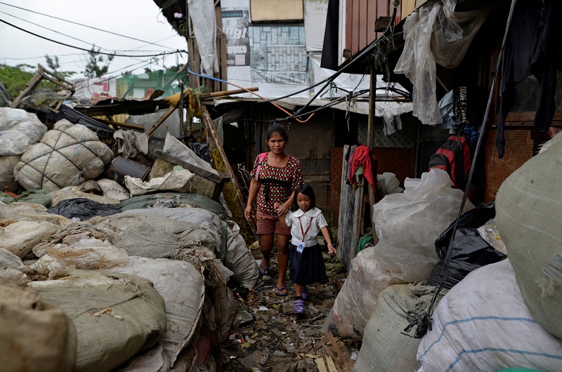 Weng Ruda, 36, mother of three walks her daughter to school at a slum area in Quezon city, Metro Manila, Philippines October 13, 2016. 