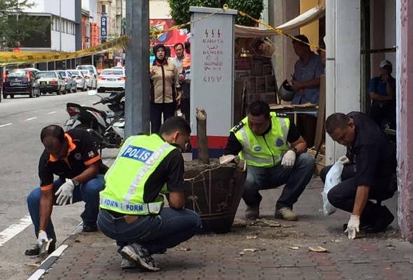 Police examining the pieces of shattered vase after the explosion at Jalan Dato Onn Jaafar. - Astro AWANI photo
