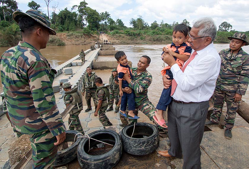 Pengarah Pendidikan Kelantan,Datuk Ab Aziz Abdullah (dua, kanan) menyambut murid prasekolah menyeberangi sungai menggunakan jet float (jambatan sementara) dengan bantuan anggota Batalion 16 Rejimen Askar Melayu Diraja (RAMD) ketika meninjau jambatan yang menghubungkan Kampung Pemberian dengan Kampung Manjor hari ini.