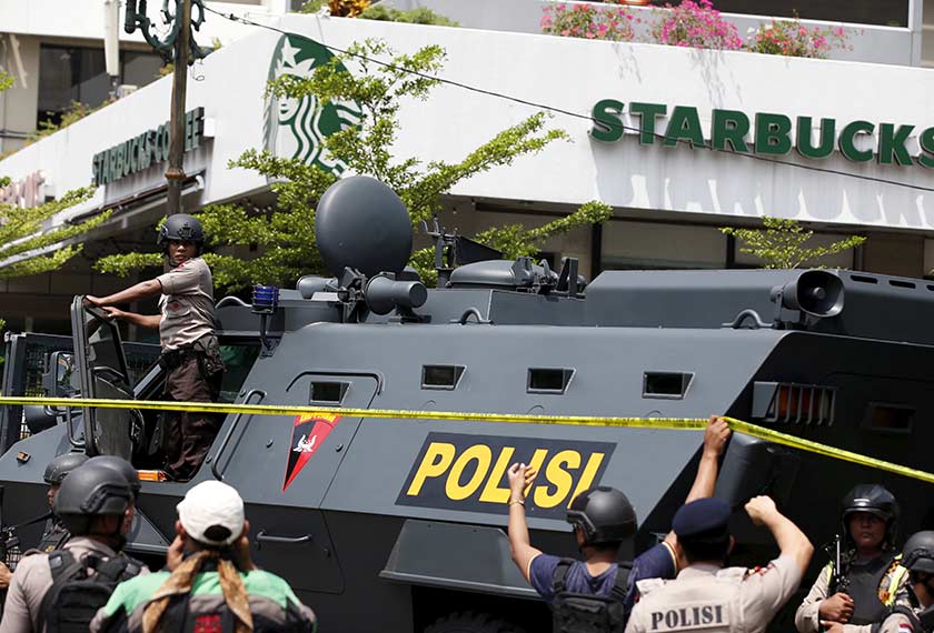 Kereta perisai polis Indonesia dikelilingi pegawai polis di hadapan sebuah kafe Starbucks di persimpangan Jalan MH Thamrin -- kawasan yang berlakunya siri letupan bom dan tembakan pagi tadi. - REUTERS