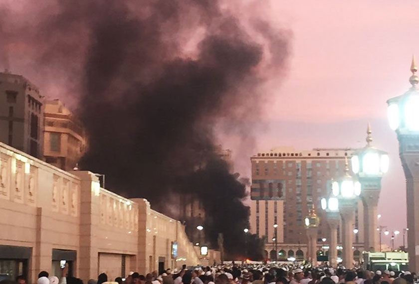 People stand by an explosion site in Madinah on July 4. - AP Photo
