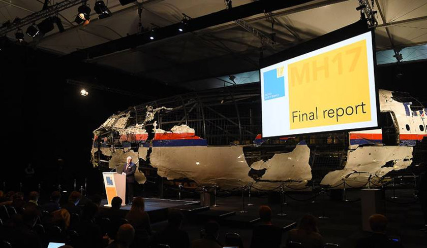 Dutch Safety Board chairman Tjibbe Joustra speaks in front of the wrecked cockpit of MH17, which is exhibited during a presentation of the final report on the cause of the its crash at the Gilze Rijen airbase in The Netherlands on Oct 13, 2015. - EPA