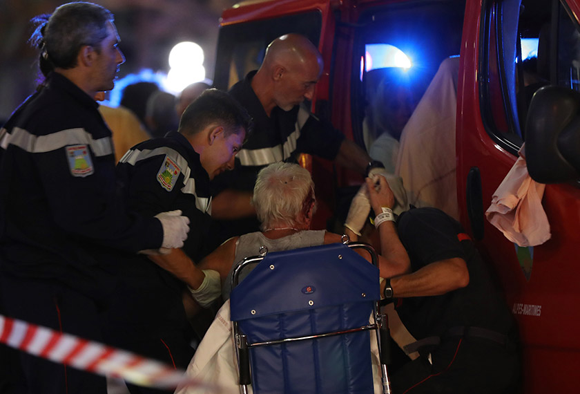 Rescue workers help an injured woman to get in a ambulance on July 15, 2016, after a truck drove into a crowd watching a fireworks display in the French Riviera town of Nice. - AFP Photo
