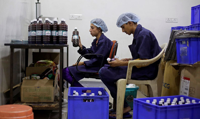 Workers label bottles of Swaarnim Natuscience Brantone+ cow urine syrup at the factory of Jain's Cow Urine Therapy Health Clinic in Indore, Madhya Pradesh, India, on June 27, 2016. (Bloomberg photo by Anindito Mukherjee)