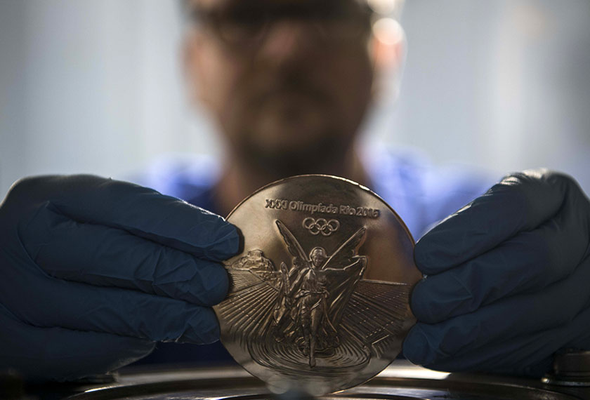 A worker holds a medal for the Rio Olympic Games at a coin factory in Rio de Janeiro, Brazil, on July 18, 2016. - AFP Photo