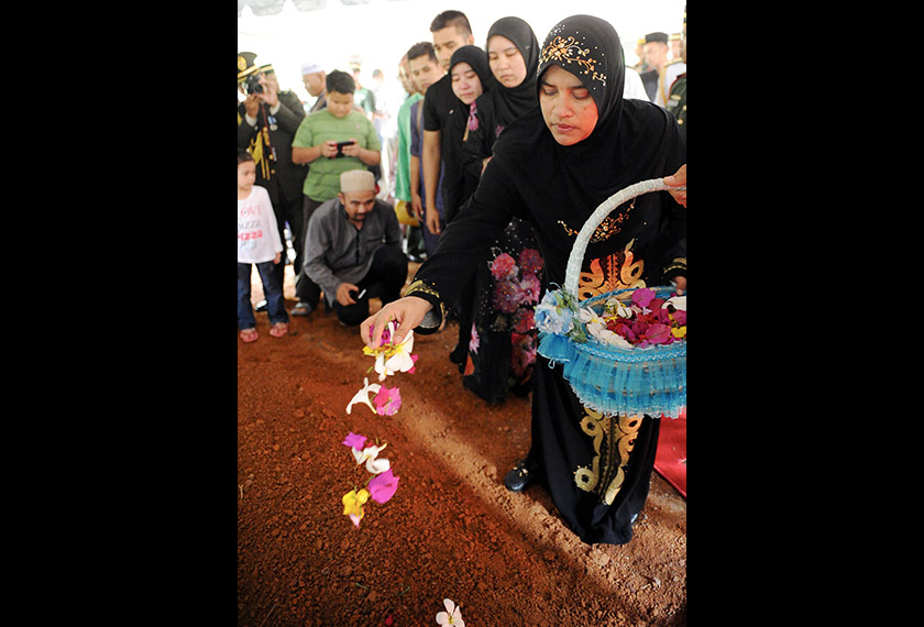 Datin Saadah Muhamad menabur bunga di pusara suaminya, Atase Pertahanan Kedutaan Malaysia di Indonesia Brig. Jen. Datuk Jalaludin Md Yusof