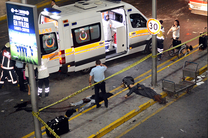 An ambulance and emergency workers intervening next to people lying on the ground, after two explosions followed by gunfire hit the Turkey's biggest airport of Ataturk in Istanbul, on June 28, 2006. - AFP PHOTO / ILHAS NEWS AGENCY