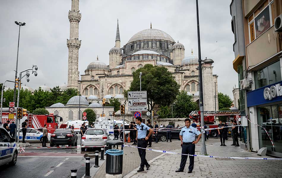 Police officers and rescuers inspect the site of a bomb attack that targeted a police bus in the Vezneciler district of Istanbul on June 7, 2016. A bomb ripped through a Turkish police vehicle near Istanbul's historic centre, killing seven officers and four civilians and adding to security concerns after a string of attacks in Turkey's biggest city.The bomb targeted a service shuttle bus carrying officers from Istanbul's anti-riot police as it was passing through the central Beyazit district close to many of the city's top tourist sites, Istanbul governor Vasip Sahin said in a live statement on Turkish television. / AFP PHOTO / OZAN KOSE