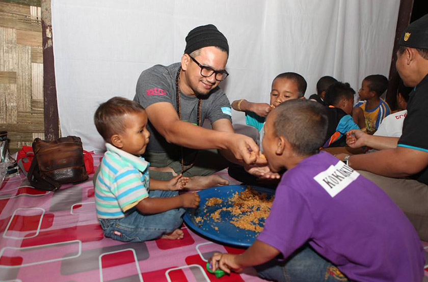 Pengacara Hajat bagi episod di Pos Balar, Erwan Muhibbain, menyuap makanan kepada anak Orang Asli. - Foto Kengkawan Project