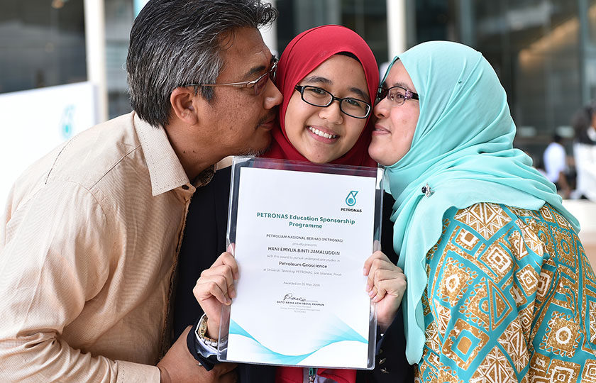 Salah seorang daripada penerima biasiswa bersama ibu bapanya selepas menerima tawaran untuk belajar di UTP di bawah tajaan PETRONAS. - Foto PETRONAS