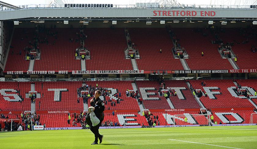 Fans leave the the Stretford End and the Sir Alex Ferguson stand (unseen) following an evacuation of both stands ahead of the Man U-Bournemouth match at Old Trafford on Sunday. - AFP Photo