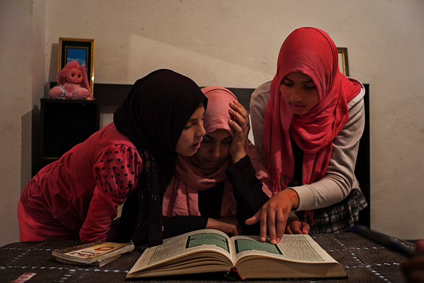 Olfa Rahmouni reads the Koran with her daughters Taysir, 11 and Aya, 13. Her older daughters Rahma, 17, and Ghofran, 18, joined ISIS and were later captured by a Libyan militia and jailed. Olfa, hoping to curb the extreme Islamist views of the two younger ones, moved to a different area in Tunis, Tunisia, to send them to a new school. The Washington Post/ Lorenzo Tugnoli.