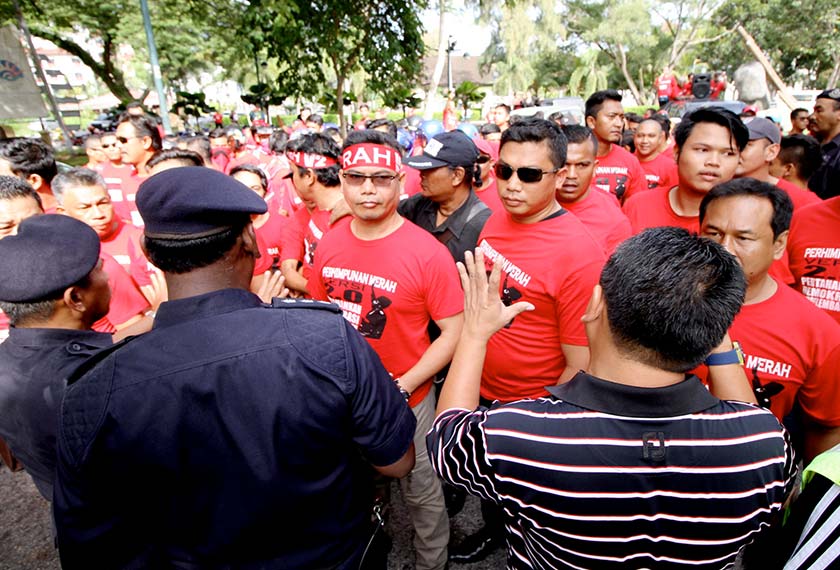 Kira-kira 50 penyokong Baju Merah berarak ke lokasi berkenaan sambil melaungkan