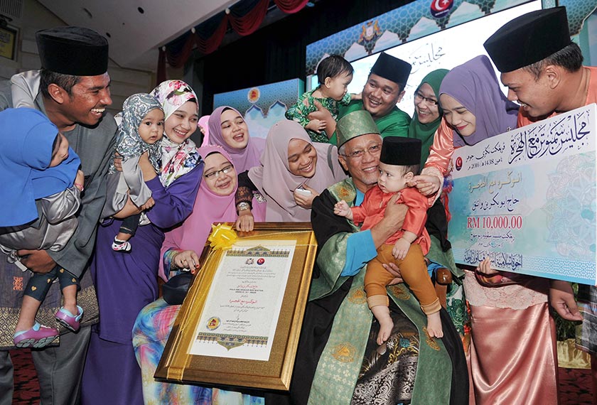 Tokoh Anugerah Maal Hijrah 1438H Abu Bakar Watak, 67, celebrating with his wife Azlin Abu Bakar, 48, (second, left) and other family members at the Dewan Besar Pusat Islam Iskandar . - BERNAMApic