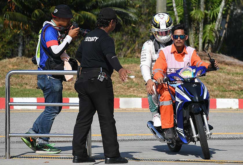 Hamilton is driven back to the pit, after his car caught fire during the Formula One Malaysian Grand Prix in Sepang on Oct 2, 2016. - AFP