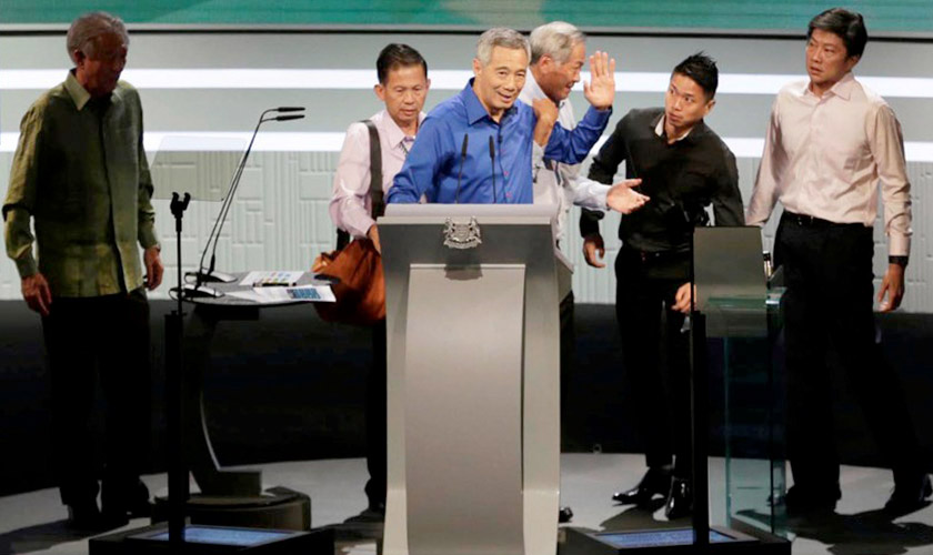 Perdana Menteri Singapura kelihatan dibantu untuk turun dari pentas sejurus jatuh sakit ketika menyampaikan ucapan Hari Kebangsaan Singapura, 21 Ogos lalu. - Wee Teck Hian/TODAY/via REUTERS