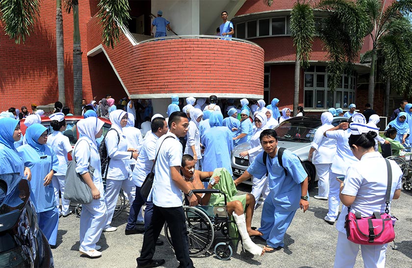Pesakit dibawa keluar dan dikumpulkan di tempat parkir di hadapan Hospital Sultanah Aminah (HSA) selepas berlaku kebakaran hari ini. - fotoBERNAMA