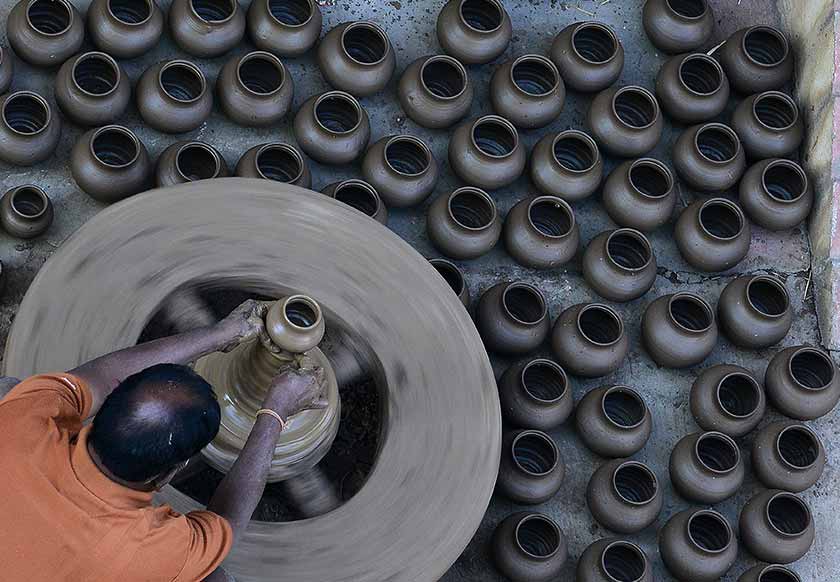 An Indian potter makes earthenware oil pots or 'diyas' at a workshop, ahead of the forthcoming Diwali festival, on the outskirts of Hyderabad on October 21, 2016. - AFP