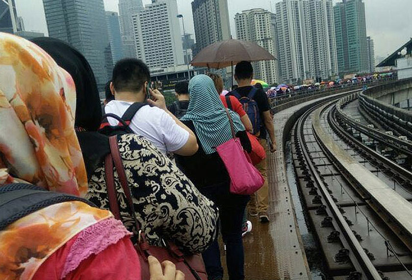 Keadaan penumpang yang terpaksa keluar dari tren dan kembali ke stesen sewaktu perkhidmatan LRT tergendala. - Gambar fail/Sumber media sosial