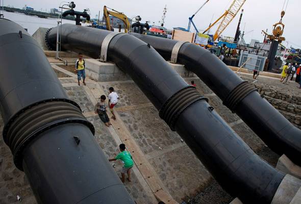 Kanak-kanak dilihat bermain di kawasan projek yang dibina untuk menghalang kemasukan air laut yang menjadi sebahagian daripada projek infrastruktur mega di utara Jakarta. - Foto AFP